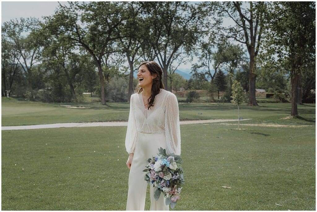 Bride laughing on Flatirons Gold Course